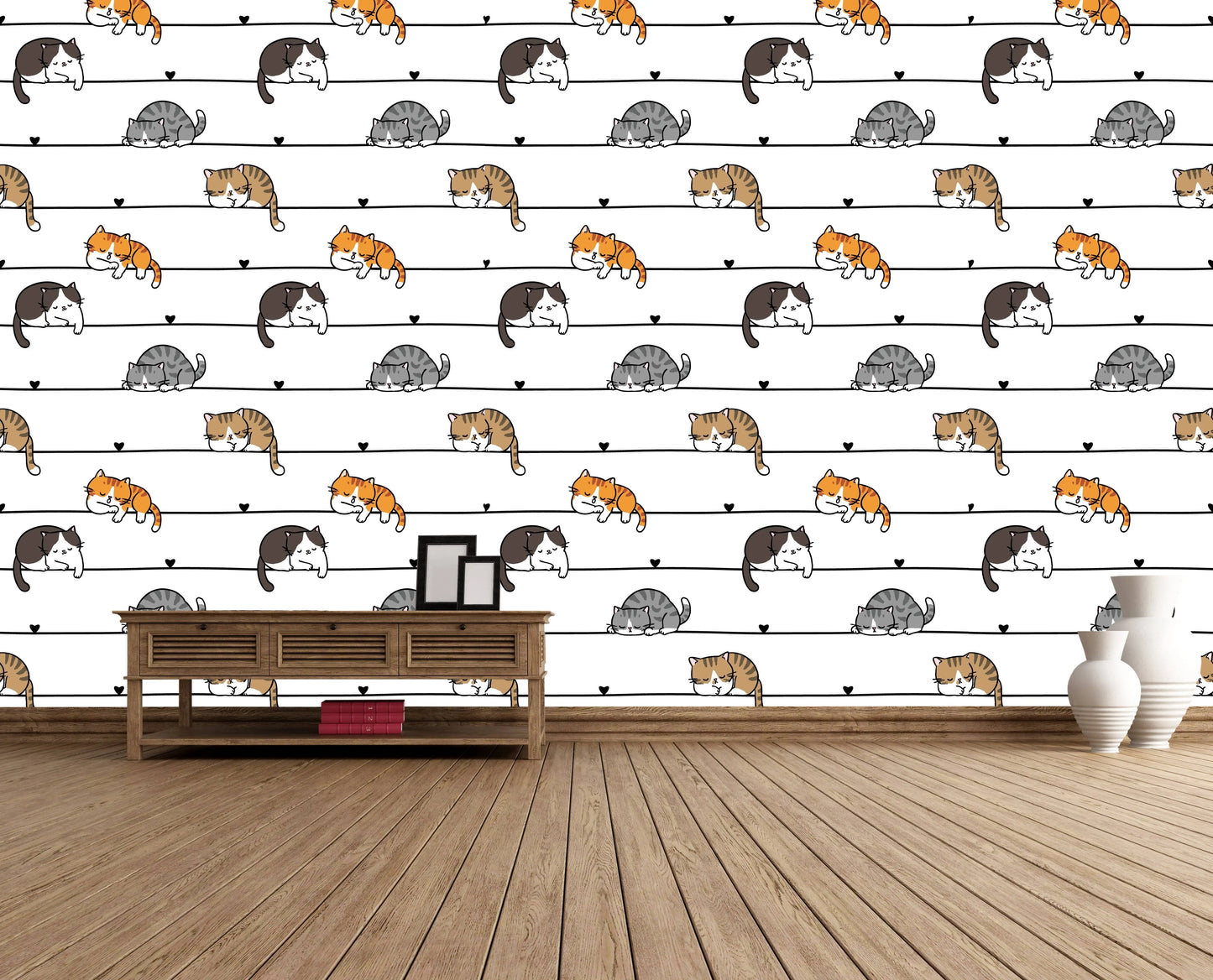 Cartoon cats wallpaper accent wall behind a wooden console table with framed photos and white vases