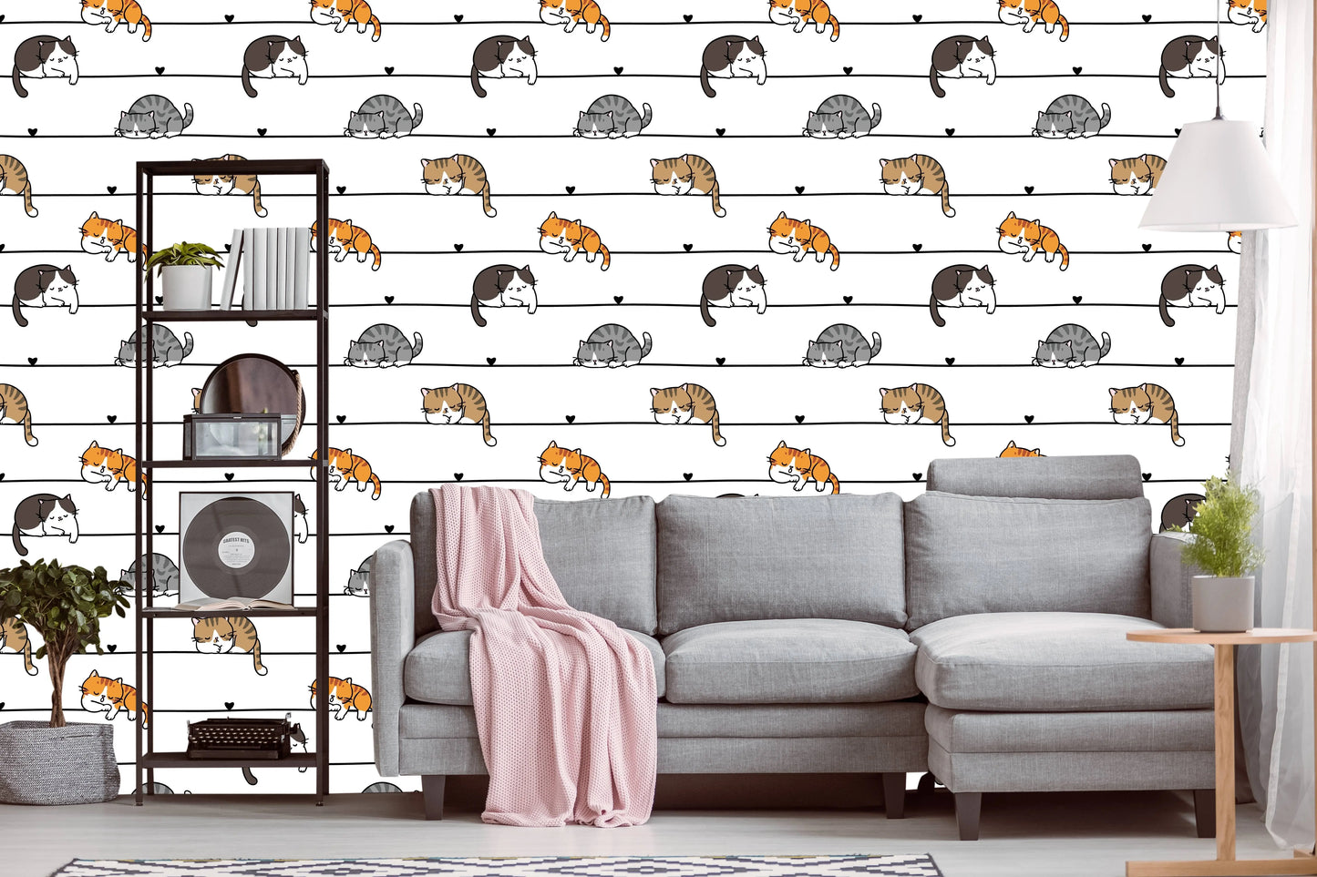 Cartoon cats wallpaper behind a gray sectional sofa and open shelving unit