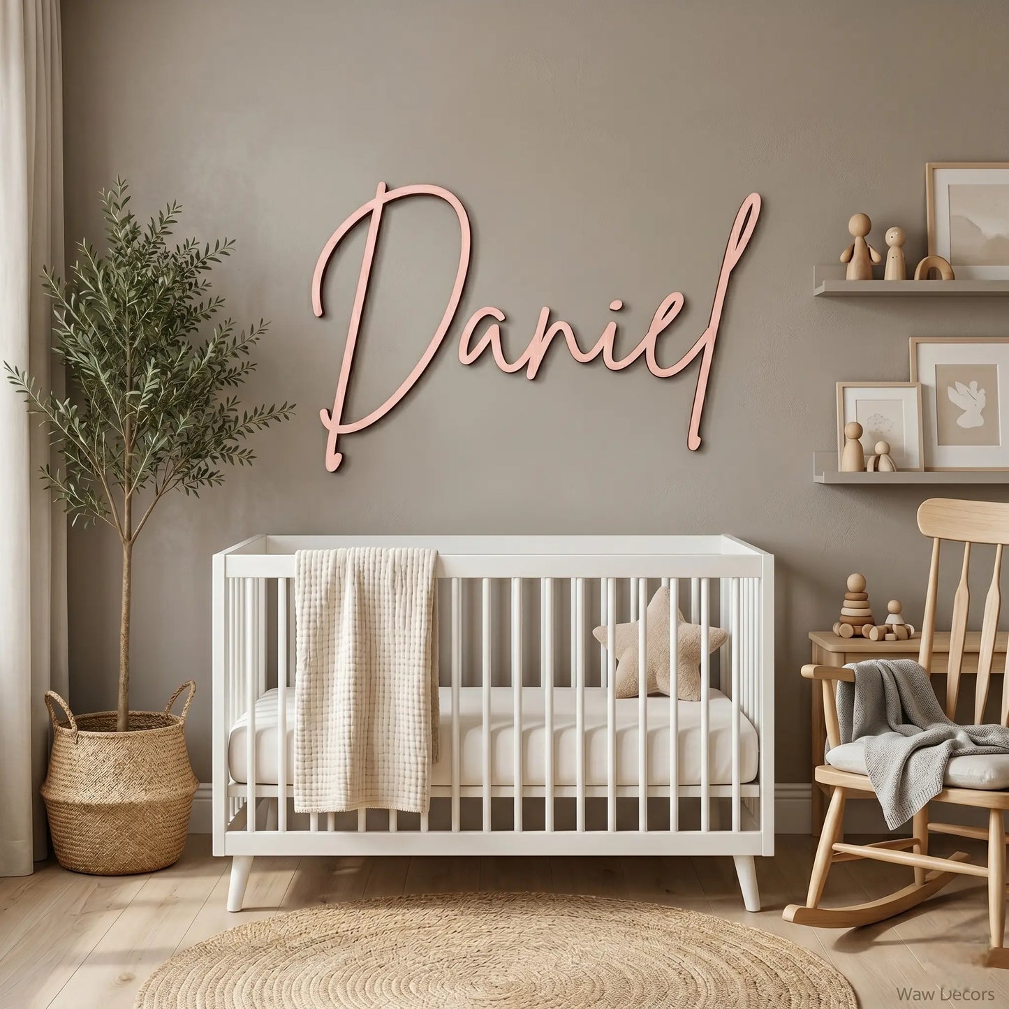 Custom wood name sign in cursive script mounted above a white crib in a nursery
