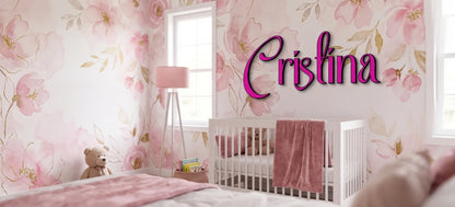 Custom wood name sign in magenta script against a pink floral wallpaper accent wall