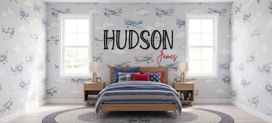Custom "Hudson James" wood name sign in a kids room with an airplane wallpaper mural
