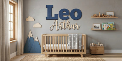 Custom "Leo Arthur" wood name sign in navy script against a mountain-themed nursery wallpaper