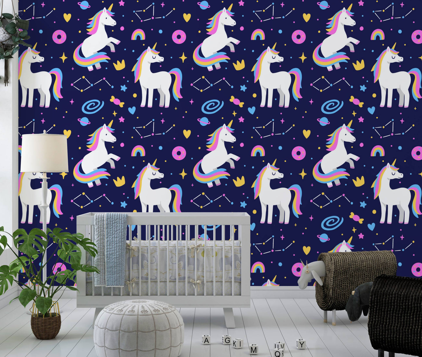 Galaxy unicorns wallpaper behind a gray crib with a monstera plant and floor lamp
