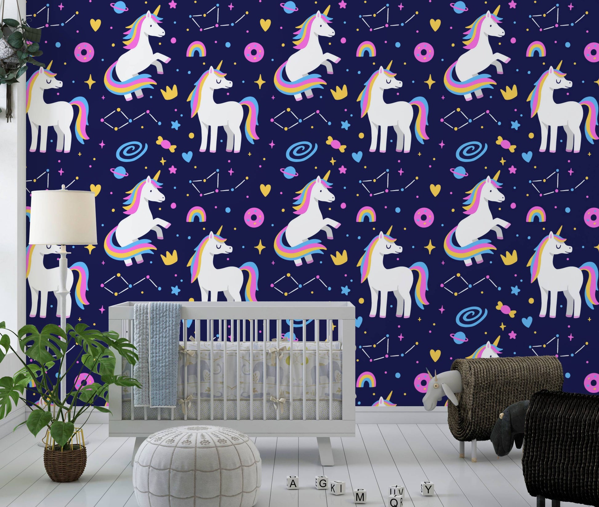 Galaxy unicorns wallpaper behind a gray crib with a monstera plant and floor lamp