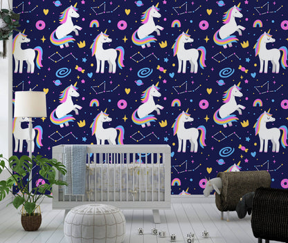 Galaxy unicorns wallpaper behind a gray crib with a monstera plant and floor lamp