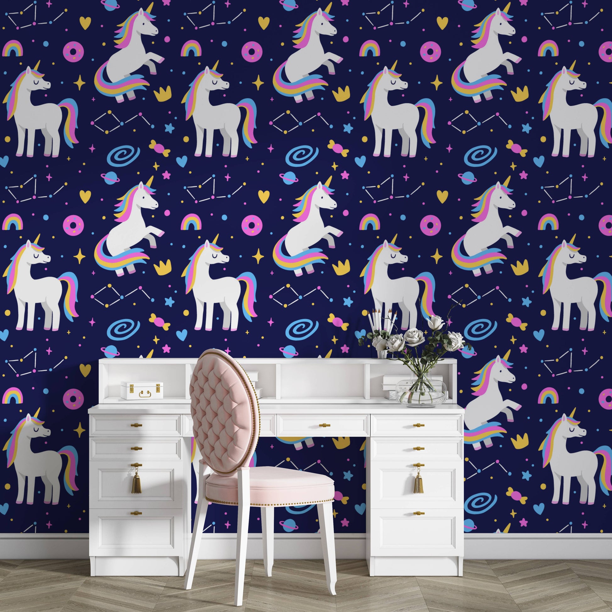 Galaxy unicorns wallpaper behind a white vanity desk with a pink chair and fresh roses
