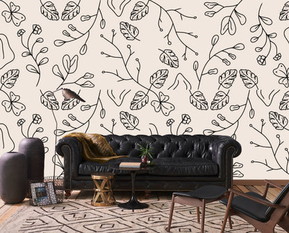 Minimal botanical line art wallpaper behind a black leather chesterfield sofa in a living room