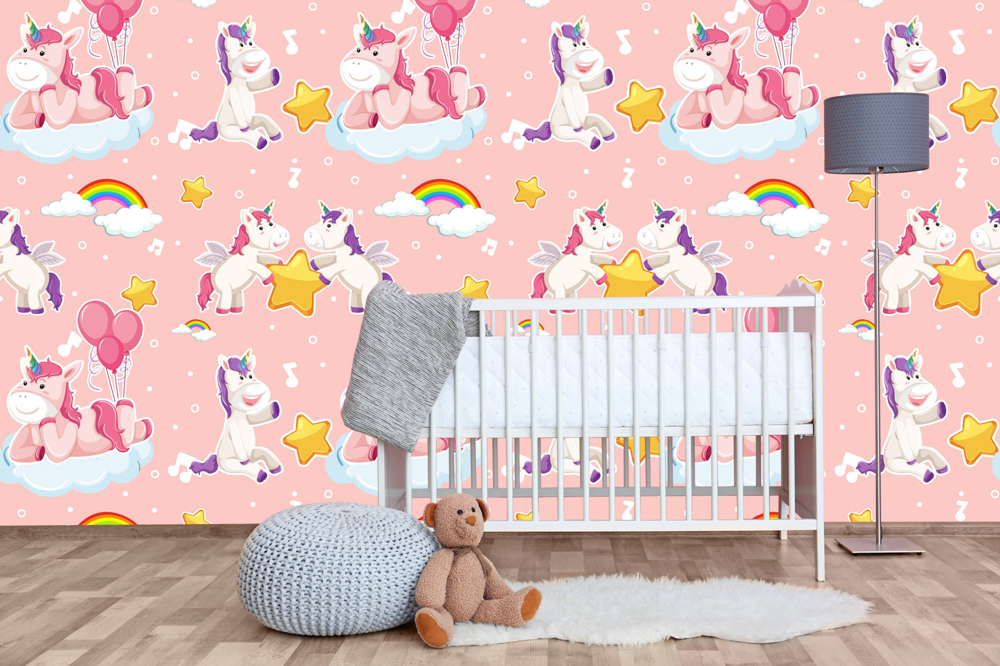 Unicorn clouds nursery wallpaper behind a white crib with a teddy bear and knit pouf