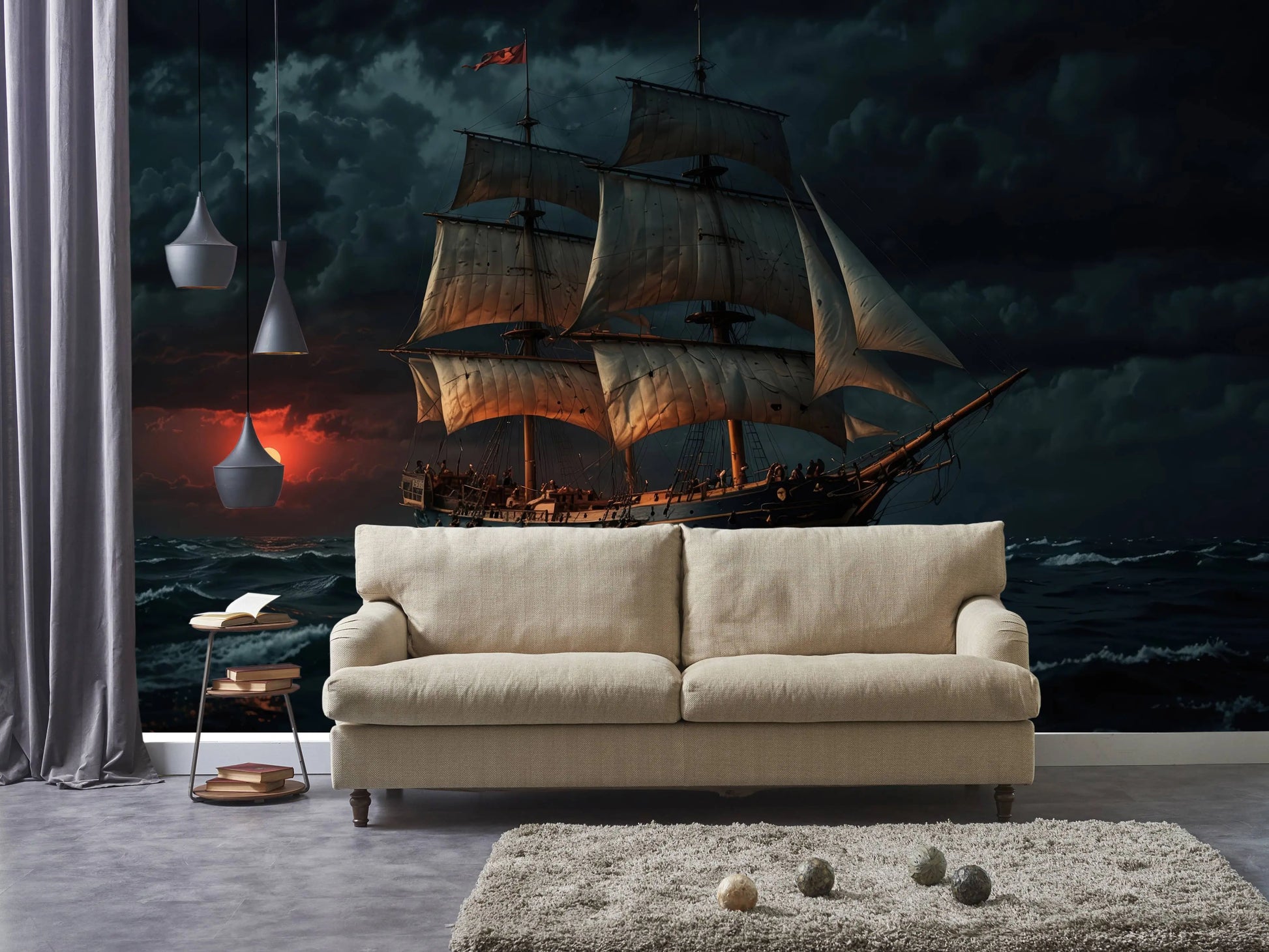 Vintage sailing ship wall mural with a dramatic sunset seascape, behind a cream sofa with pendant lighting and curtains
