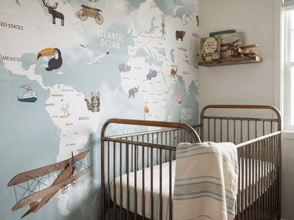 World explorer map wallpaper behind a metal crib with a book shelf and toy airplanes